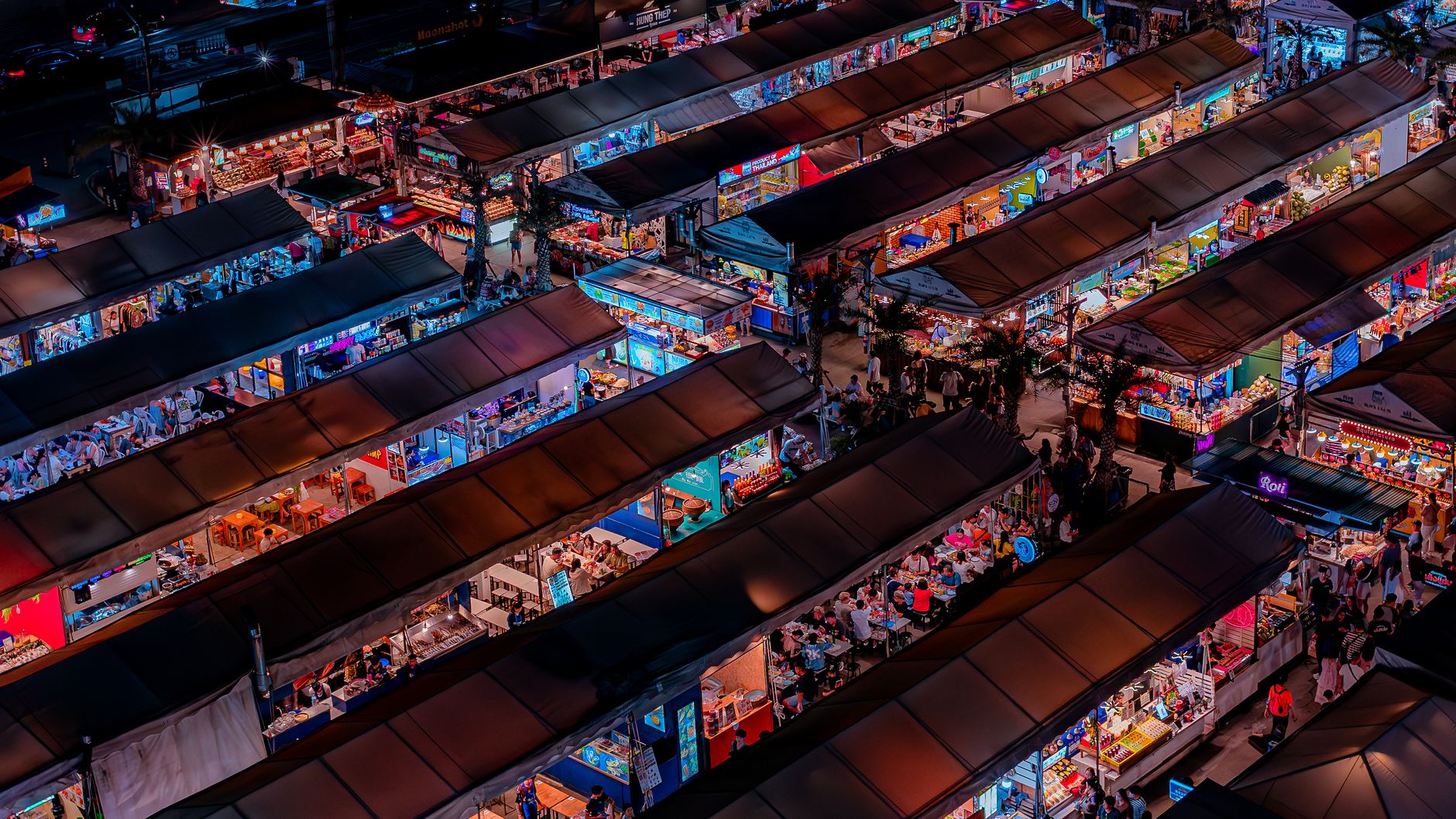 Rows of lit market stalls seen from above at night (illustrative stock photo).